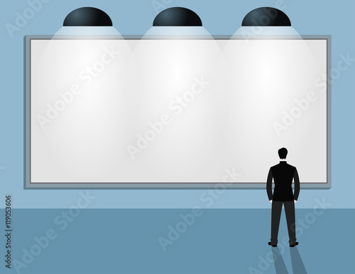 Man in suit looking at blank billboard
