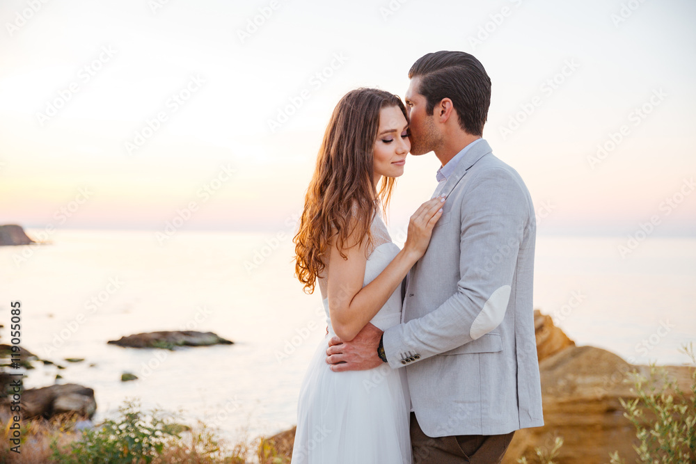 Romantic married couple kissing on the beach