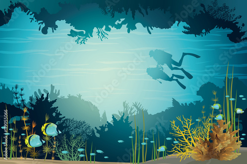 Two scuba divers and underwater cave with fish.