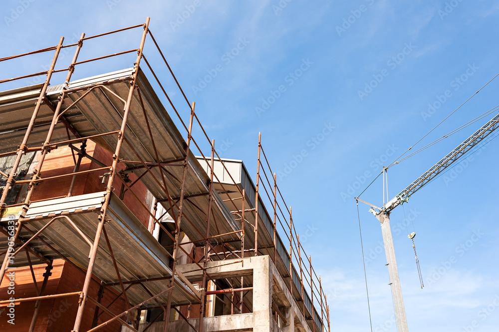 House for renovation with the scaffolding for bricklayers House for renovation with the scaffolding for bricklayers