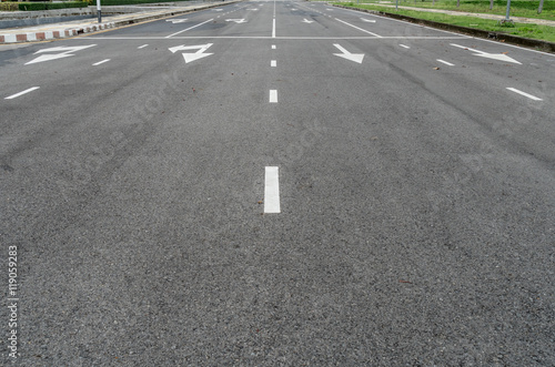 Asphalt road with arrow sign and white dot line © santagig