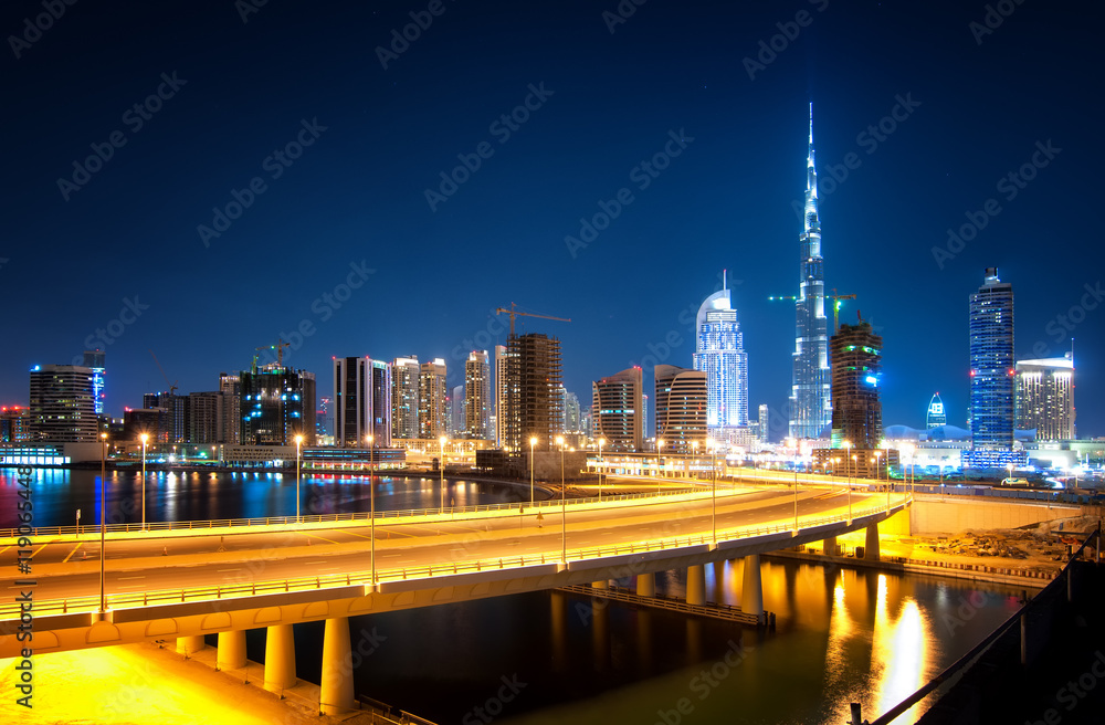 Fototapeta premium Fascinating reflection of tallest skyscrapers in Business Bay district during calm night with amazing bridge. Downtown summer day. , Downtown, Dubai, United Arab Emirates.