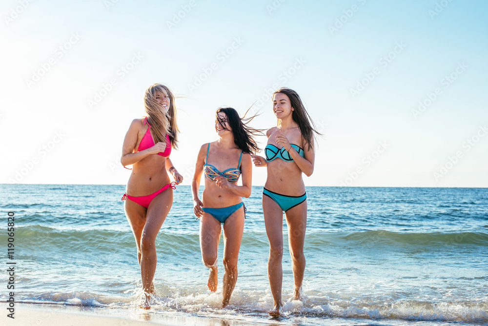 three girls having fun on beach, friends on beach in sunset light three girls having fun on beach, friends on beach in sunset light