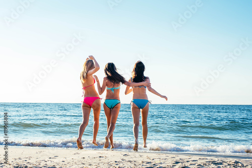 three girls having fun on beach, friends on beach in sunset light © kurapatka