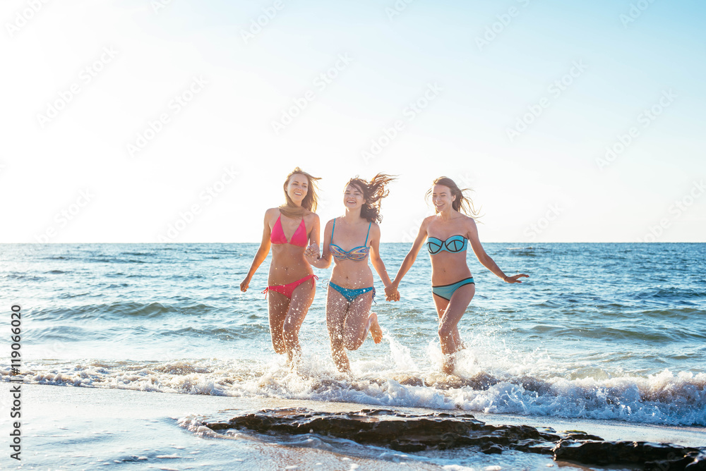 three girls having fun on beach, friends on beach in sunset light three girls having fun on beach, friends on beach in sunset light