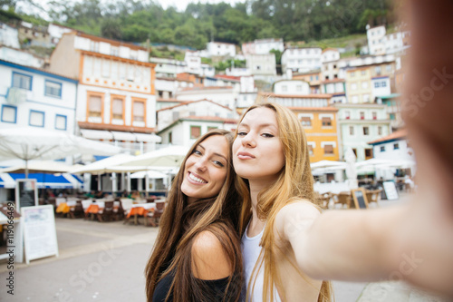 Two best friends making self-portrait in city photo