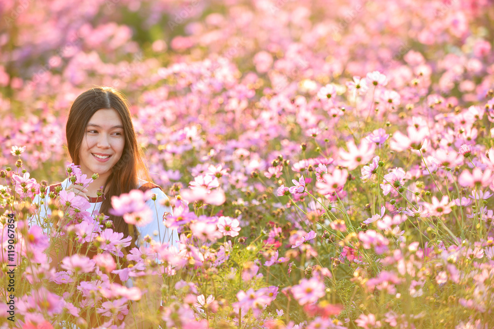 Woman and Cosmos flowers blooming in the garden Woman and Cosmos flowers blooming in the garden
