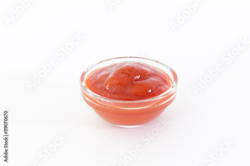 Ketchup in glass on white background