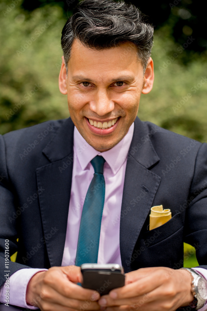Smiling Businessman Texting On Cell / Mobile Phone Smiling Businessman Texting On Cell / Mobile Phone