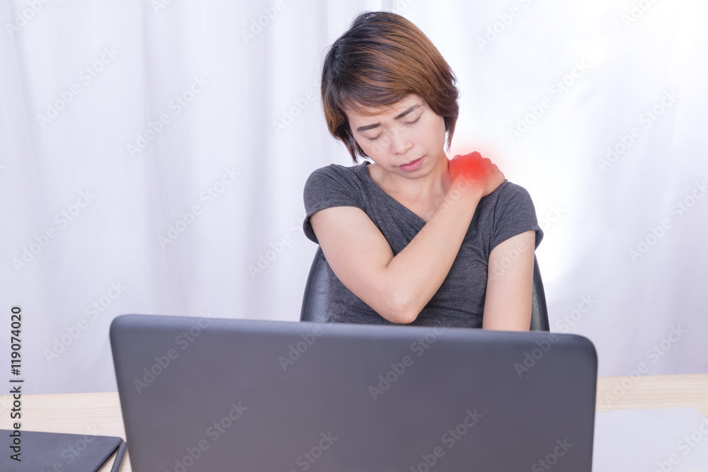 Young business person with neck or shoulder pain and massaging her shoulder Young business person with neck or shoulder pain and massaging her shoulder