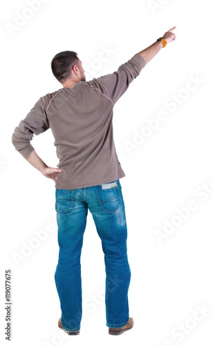 young man pointing at wall. rear view. Isolated over white .
