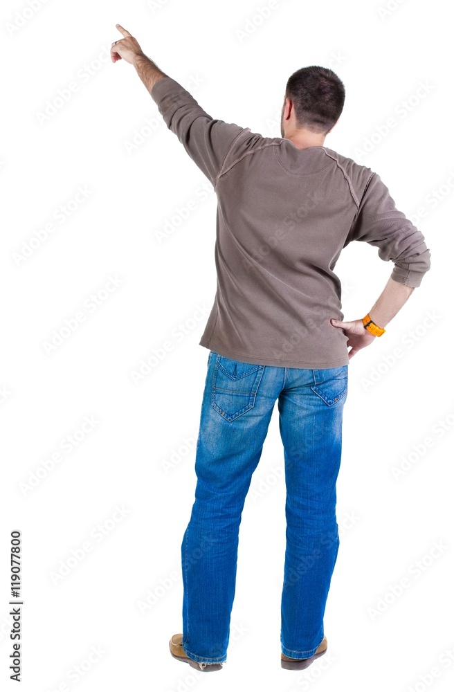 young man pointing at wall. rear view. Isolated over white . young man pointing at wall. rear view. Isolated over white .