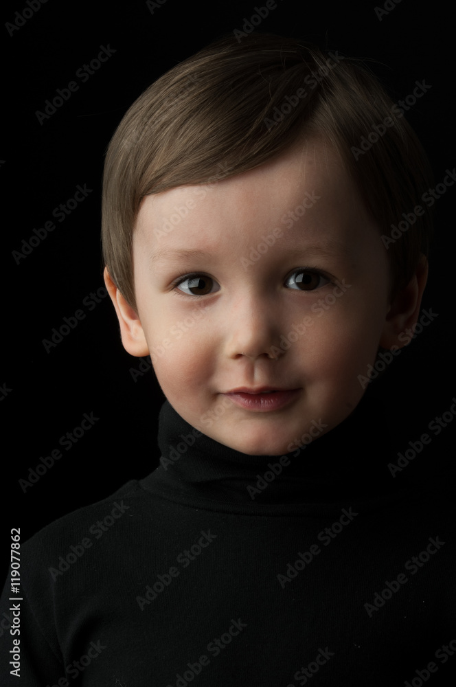portrait of a little boy on a dark background portrait of a little boy on a dark background