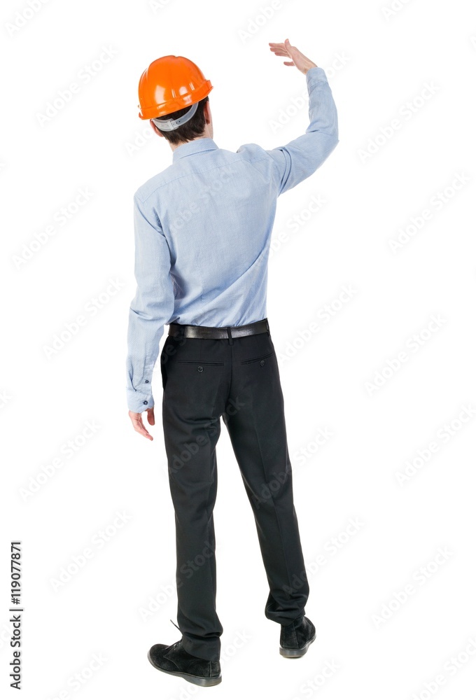 Backview of an engineer in construction helmet stands. Standing young guy. Rear view people collection. backside view of person. Isolated over white background. Engineer beckons to her employee. Backview of an engineer in construction helmet stands. Standing young guy. Rear view people collection. backside view of person. Isolated over white background. Engineer beckons to her employee.