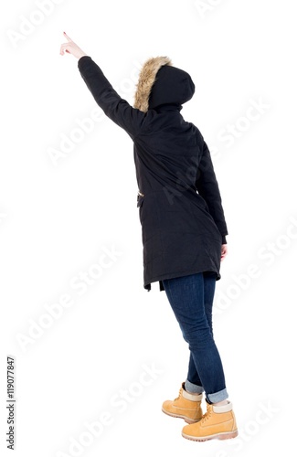 Back view of pointing young women in parka. Young girl gesture. Rear view people collection. backside view of person. Isolated over white background. 