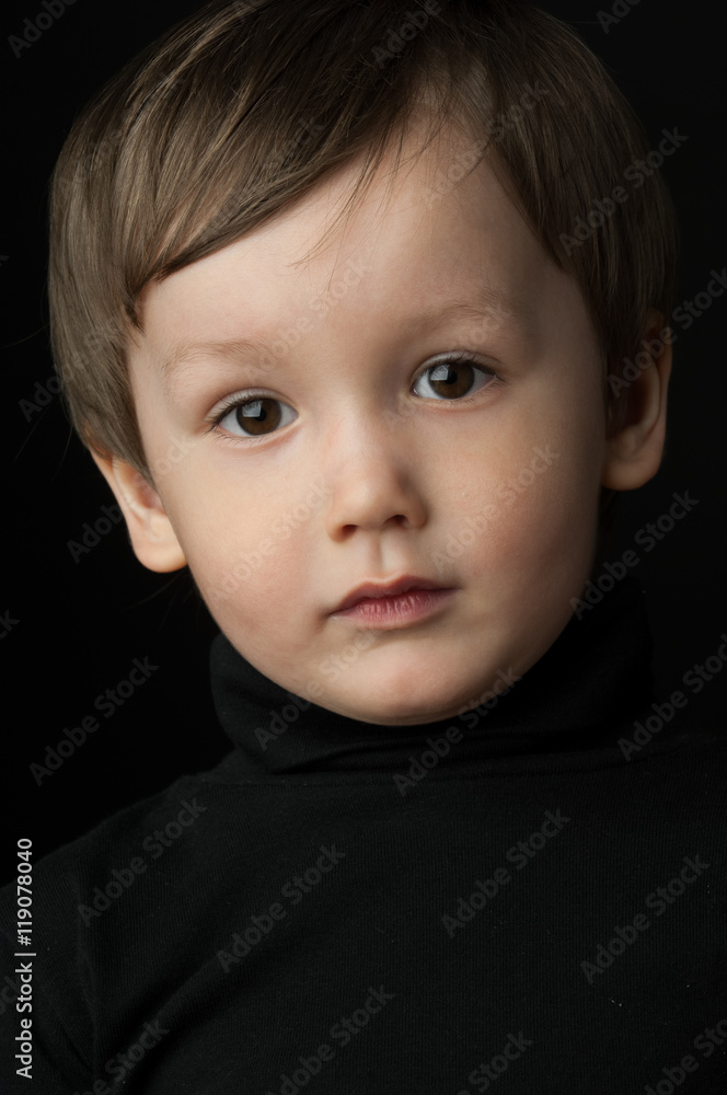 portrait of a little boy on a dark background portrait of a little boy on a dark background