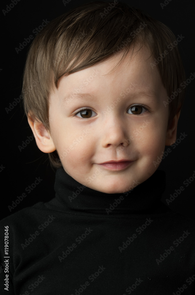 portrait of a little boy on a dark background portrait of a little boy on a dark background