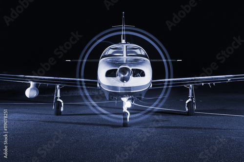 The small single-engine piston aircraft on the runway, illuminat