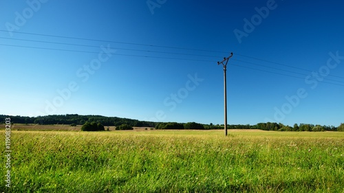 Summer meadow with single electric pillar