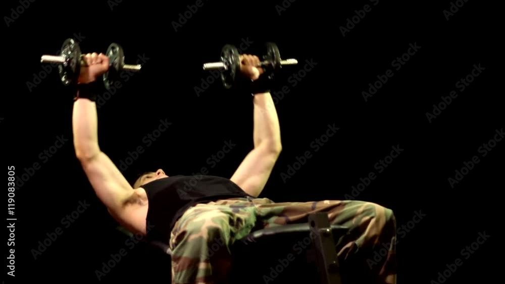 Dumbbell chest press exercise. Studio shot over black.
Dumbbell chest press exercise. Studio shot over black.