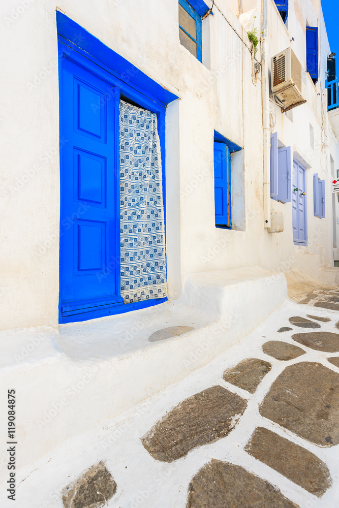 Fototapeta premium Blue door and windows of typical house on street of beautiful Mykonos town, Cyclades islands, Greece