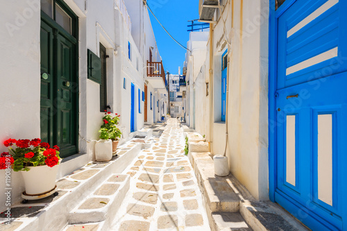 Typical white Greek houses with blue doors and windows on street of beautiful Mykonos town  Cyclades islands  Greece