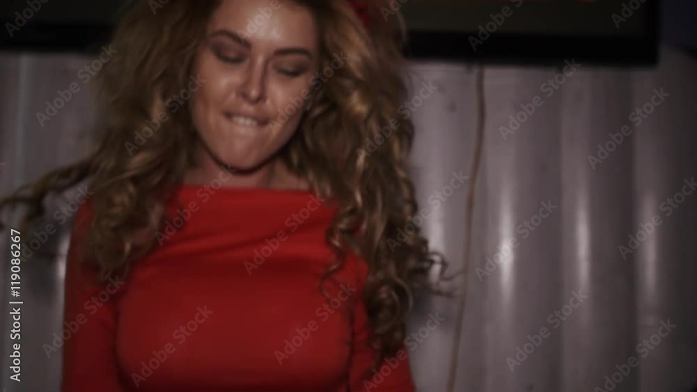 Happy dj girl in red dress with rim on head jump at turntable in nightclub. Music. Slow motion Happy dj girl in red dress with rim on head jump at turntable in nightclub. Music. Slow motion