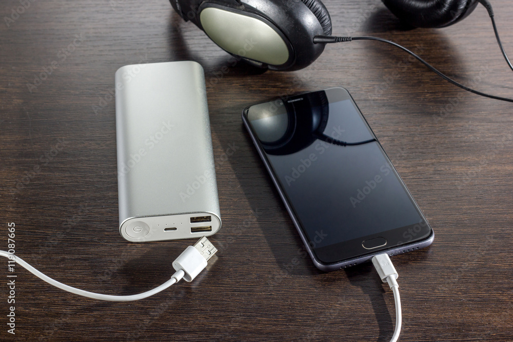mobile phone and power bank battery on dark background mobile phone and power bank battery on dark background