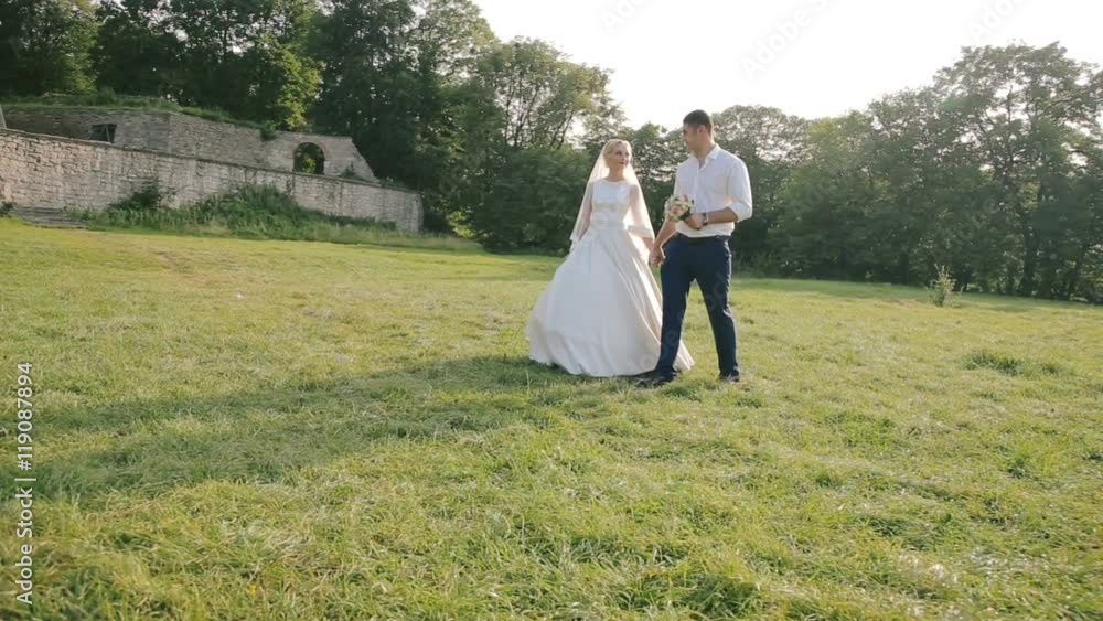 Wedding couple walking outdoor near the old castle Wedding couple walking outdoor near the old castle