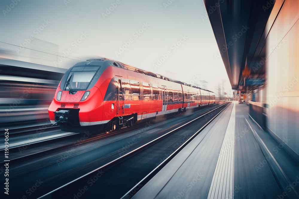 Obraz premium Piękna stacja kolejowa z nowoczesnym czerwonym pociągiem podmiejskim w moti
