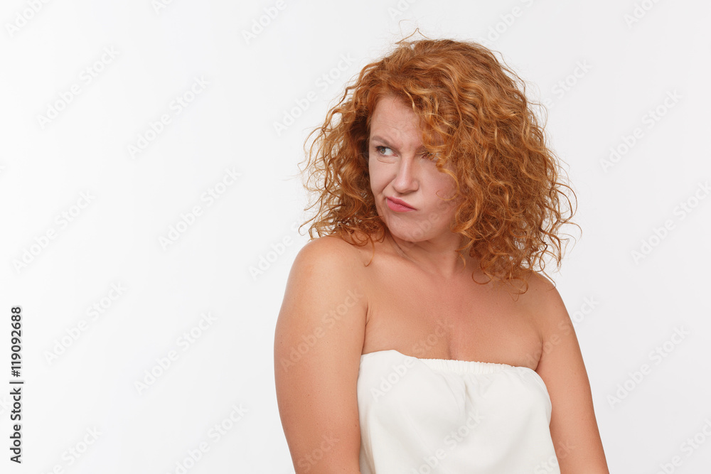 Portrait of doubtful mature woman looking away while posing in studio. Red  haired lady in white dress posing isolated on white background. Stock Photo  | Adobe Stock