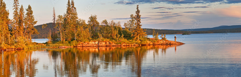 Lake panorama at sunset in Sweden with the lonely fisherman. Lake panorama at sunset in Sweden with the lonely fisherman.