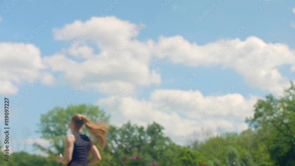 FItness woman running in slow motion at background of blue sky with clouds. Caucasian woman running outdoor. Fitness workout outdoor. Running woman at summer day. Girl running at sky background FItness woman running in slow motion at background of blue sky with clouds. Caucasian woman running outdoor. Fitness workout outdoor. Running woman at summer day. Girl running at sky background