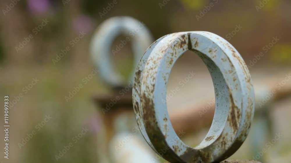 A rusty fence outside the building it is white round shape the tip of the fence A rusty fence outside the building it is white round shape the tip of the fence