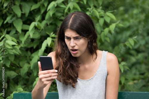 Frustrated Woman Looking At Mobile Phone