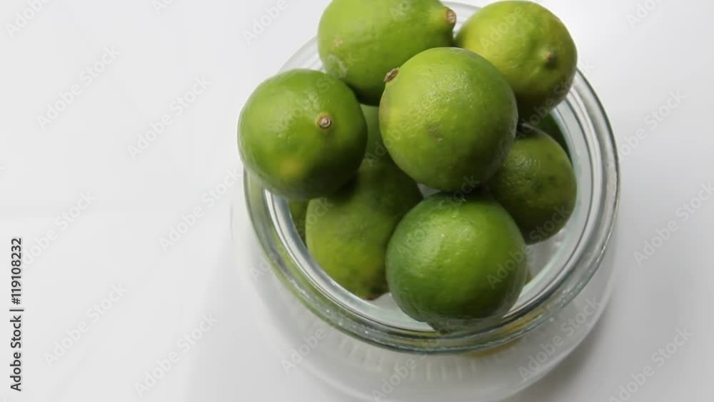 View of green limes in a container from above View of green limes in a container from above