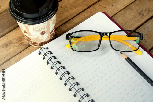 Notebook with a pencil and glasses.