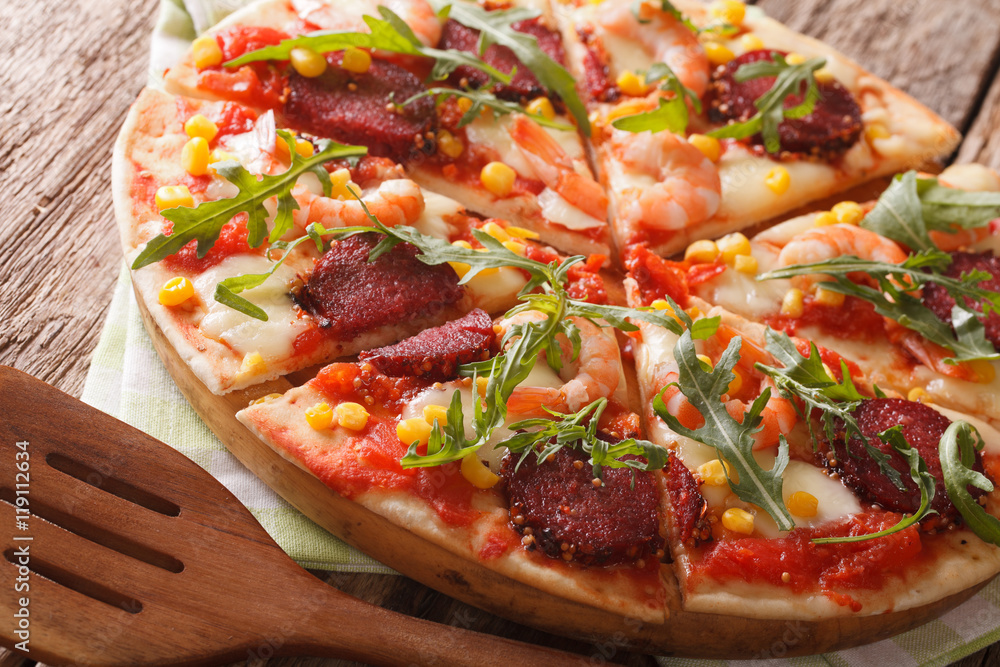 Tasty pizza with salami, shrimp, mozzarella and arugula close-up. horizontal
Tasty pizza with salami, shrimp, mozzarella and arugula close-up. horizontal