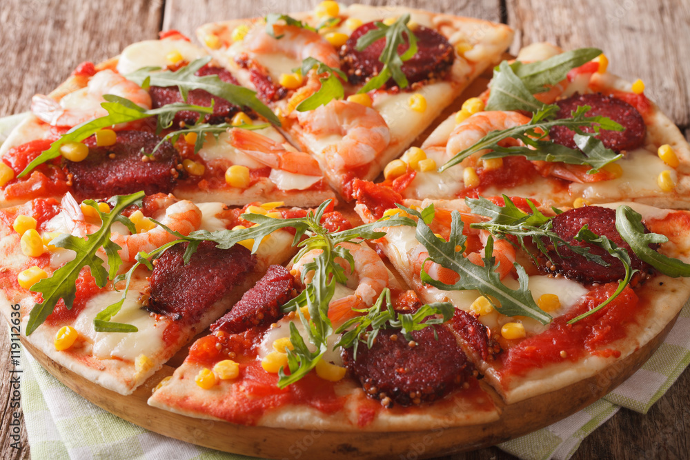 Pizza with salami, shrimp, mozzarella and arugula close-up. horizontal
Pizza with salami, shrimp, mozzarella and arugula close-up. horizontal