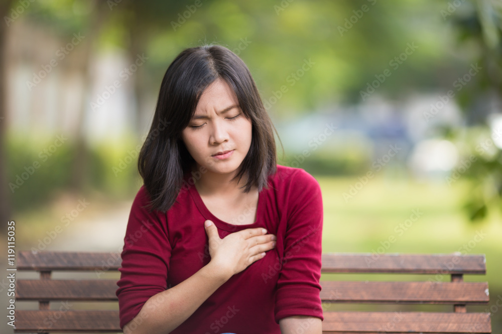 Woman Has Chest Pain Sitting on Bench at Park Woman Has Chest Pain Sitting on Bench at Park
