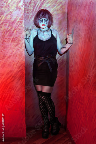 girl with makeup zombies standing in red wall