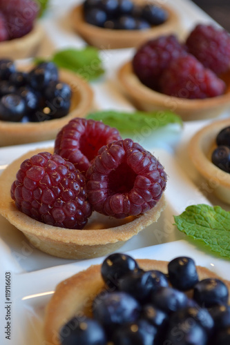 Fruit tarts. Round pastry with red and black berries.