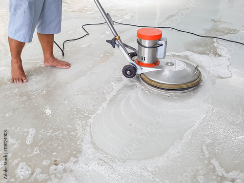 worker using scrubber machine for cleaning and polishing floor