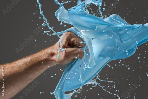 Fotografi Close-up of a man's fist punching through liquid