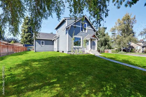 Blue clapboard siding house with grass filled front yard.