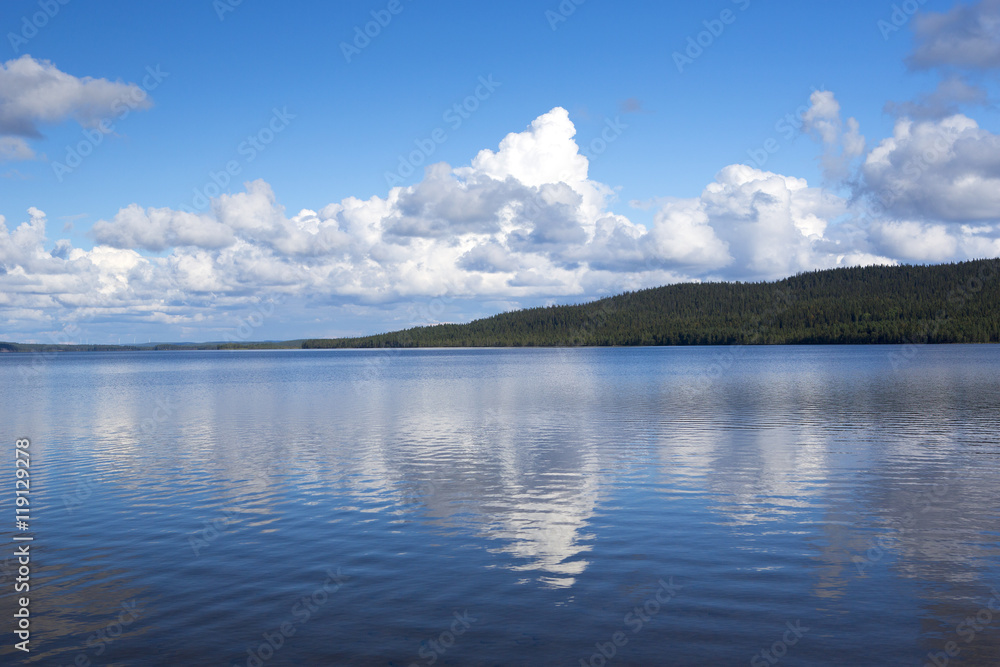 Beautiful summer view. Image taken in Finland on a summer afternoon with blue sky and clouds. Clouds are reflecting from the water.