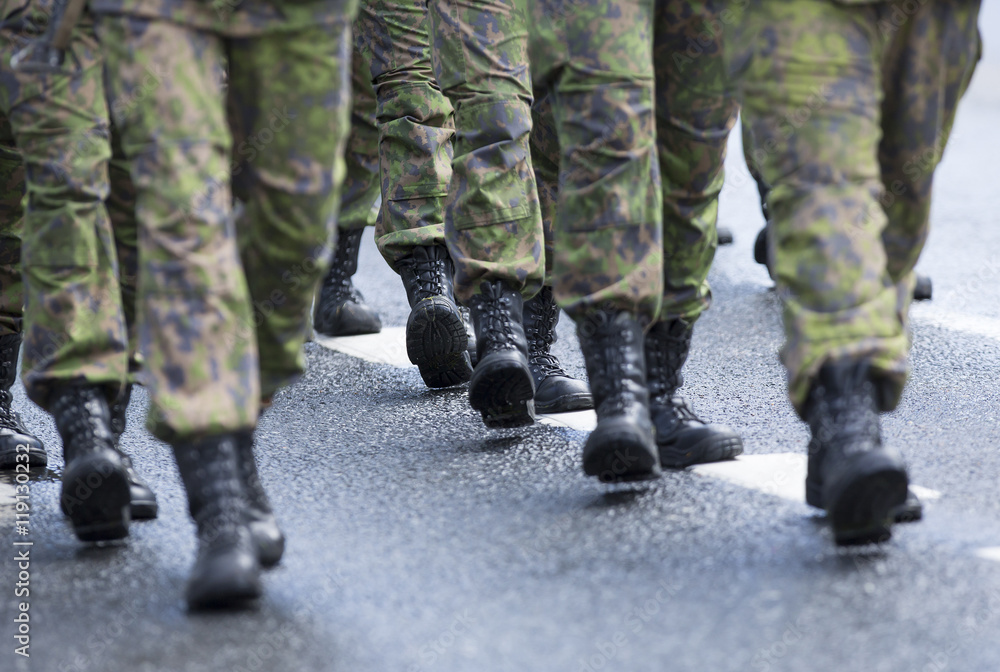 Soldiers marching on the asphalt road. Image of black boots and camouflage clothes. Soldiers marching on the asphalt road. Image of black boots and camouflage clothes.