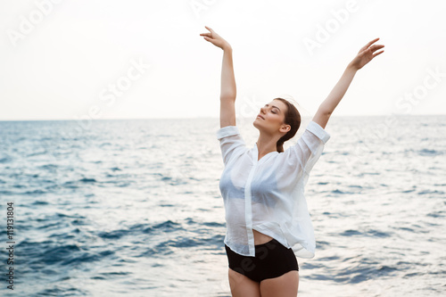 Young beautiful ballerina dancing and posing outside, sea background. © Cookie Studio