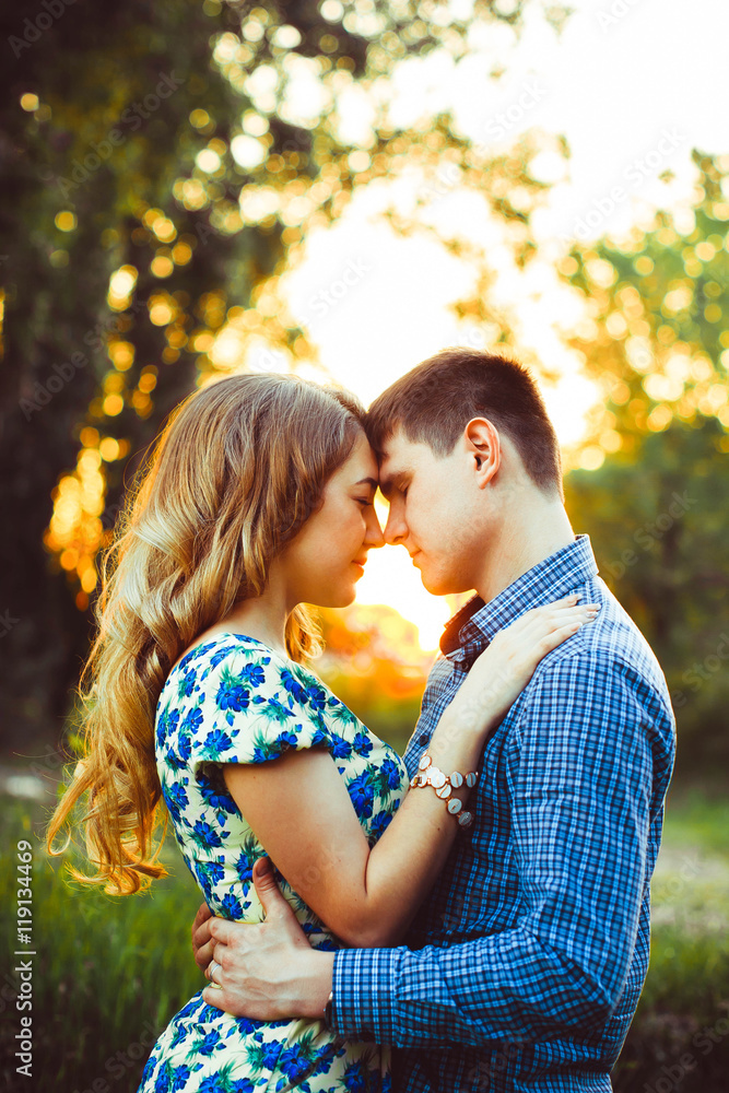 Lovers having touched their heads are in the last rays of the sun on the field. Lovers having touched their heads are in the last rays of the sun on the field.