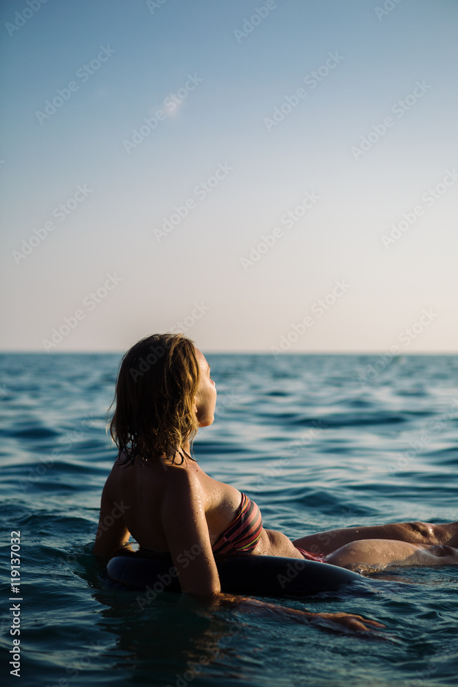 Rear view of unrecognizable young woman with short hair in bikini